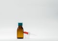 Medicine syrup in amber bottle with blank label and a plastic measuring cup, dropper Royalty Free Stock Photo