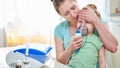 Medicine on the table. the woman holds the child, checks the temperature by applying a palm to the child`s head. I feel bad