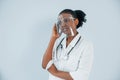 Medicine worker. Young african american woman is against white background