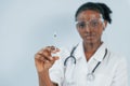 Medicine worker. Young african american woman is against white background