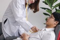 Medicine young doctor with stethoscope examining Asian male patient in medical office Royalty Free Stock Photo