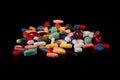 Medicines in capsules of many colors on a black background Royalty Free Stock Photo