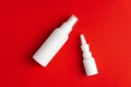 Medicines for treatment of nose and throat. Nasal and throat spray bottles on red background. Mockup Royalty Free Stock Photo