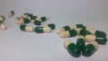 Medicines in the form of green capsules that have expired on a green background