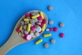 Medicines in the form of tablets and capsules lie on a wooden spoon Royalty Free Stock Photo