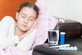 Medicines and glass of water for ill sleeping child