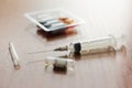 Medicines, injectable ampoules and syringe on the table