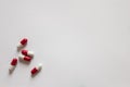 Medicines, pills. Medical background, red-white capsules on a white background. Top view of pills on white surface Royalty Free Stock Photo