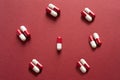 Medicines, pills. Medical background, red-white capsules on a red background. Top view of pills on red surface Royalty Free Stock Photo