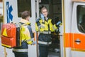 Medics in front of ambulance talking to headquarters using radio Royalty Free Stock Photo