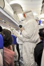 Medics in white protective suits checking and scanning passengers in a plane for epidemic virus symptoms. Chinese new Wuhan Royalty Free Stock Photo