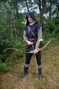 Medieval archer with black hood and coloured arrows in the quiver stands with arrow Royalty Free Stock Photo