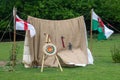 Medieval archery target board in field with welsh flag and george cross