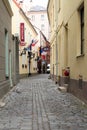 Riga, Latvia, November 2019. Old narrow street, signboards of hotels and multi-colored flags.