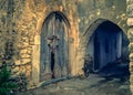 Medieval archway, old arched wooden gate, abandoned alley of a traditional village of Crete. Royalty Free Stock Photo