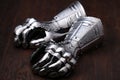 Medieval armor, detail of an ancient armor. Steel gloves on wooden background. Royalty Free Stock Photo