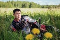 A medieval Asian warrior in armor is resting while sitting in tall grass Royalty Free Stock Photo