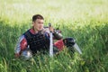 A medieval Asian warrior in armor is resting while sitting in tall grass Royalty Free Stock Photo