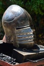 Medieval bascinet helm with liftable face mask on hinge placed on weaponsmith work table Royalty Free Stock Photo