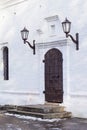 Medieval black door with metal in white wall of church Royalty Free Stock Photo