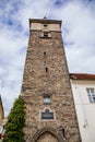 Medieval black gothic tower in center of Plzen in sunny summer day, masonry wall, prismatic water tower, pyramidal roof, part of