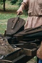 Medieval blacksmith using bellows to kindle fire