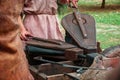 Medieval blacksmith using pair of bellows to light fire