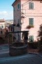 A medieval brick water well in the middle of a staircase in an ancient Italian village Corinaldo, Marche Royalty Free Stock Photo