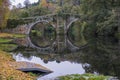 Fall foliage and medieval Roman bridge reflected on the river Arnoia in the Galician village of Allariz, Ourense. Spain.