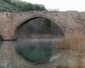 Medieval bridge reflected in the water in Spain over the river with fog Royalty Free Stock Photo
