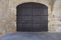 Medieval Brown Wooden Door in Stone Wall. Old castle stone wall with big wooden doors.