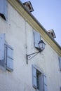 Medieval building with outdoor lamp filtered. Facade of old house with window shutters. Ancient architecture concept. Royalty Free Stock Photo