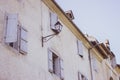 Medieval building with outdoor lamp filtered. Facade of old house with window shutters. Ancient architecture concept. Royalty Free Stock Photo