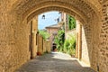 Medieval buildings of the old town of Assisi through a stone arch, Italy