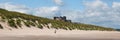 Medieval castle by a beach Bamburgh Northumberland north England UK with white sand panoramic view