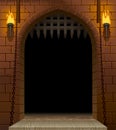 Medieval castle gate with a drawbridge and torches with a black Royalty Free Stock Photo