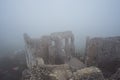 Medieval castle ruin in heavy fog view from high point