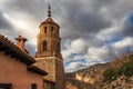 Medieval church of the city of Albarracin with cloudy sky background and sun flare over the stone roofs of the city. Teruel Spain Royalty Free Stock Photo