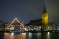 The medieval church with decorated sailing ship in Harlingen in Netherlands at night