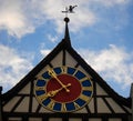 Medieval clock in tower of old building with blue sky background. The clock of hands marks 7:55 at the top of the tower there is a