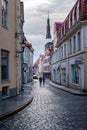 Medieval cobbled street with couple strolling down the street. Tallinn Royalty Free Stock Photo