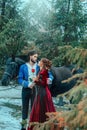 Medieval couple in love man and woman hugging in winter forest. Vintage clothing red long dress. Blue costume tailcoat