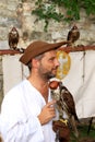 Medieval dressed falconer with hooded falcon