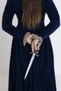 A Medieval and Fantasy woman wearing a blue velvet dress and holding a dagger