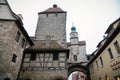 Medieval gothic clock Markusturm and half-timbered house on Rodergasse street, autumn day, Old Town fortification, Rothenburg ob