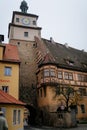 Medieval gothic clock White Tower or Weisser Turm and half-timbered house on Georgengasse street, autumn day, Old Town