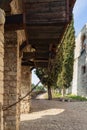 Medieval counterweight system used for the drawbridge at Brescia castle, framed by a stony arch and flanked by cypress trees