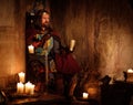 Medieval king with goblet of wine on the throne in ancient castle interior. Royalty Free Stock Photo