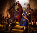 Medieval king with his knights in ancient castle interior. Royalty Free Stock Photo