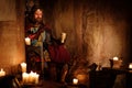 Medieval king on throne in ancient castle interior. Royalty Free Stock Photo